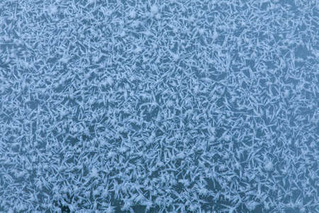 A microphotography of frozen snowflakes on the ice perfect for using as a winter backgroundの写真素材