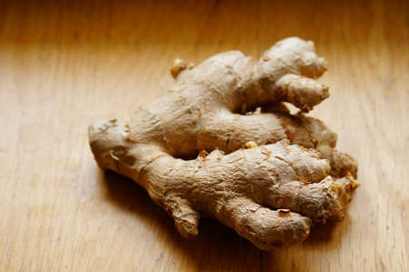 A high angle closeup shot of raw ginger on a wooden surface