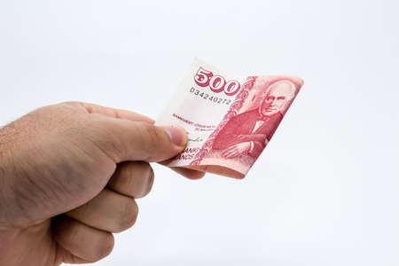 A closeup shot of a person holding some cash over a white backgroundの写真素材