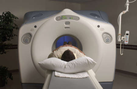 A person lying in an MRI scanner under the lights in a hospitalの写真素材