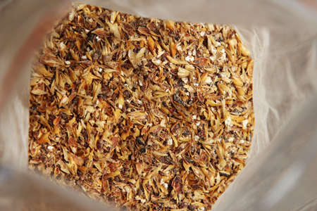 Milled malted barley(grist) inside a plastic packet which will be used to make craft beer.