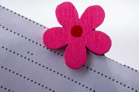 A closeup shot of an artificial pink flower in front of a white backgroundの写真素材