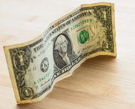 A high angle shot of an American dollar bill on a wooden surface