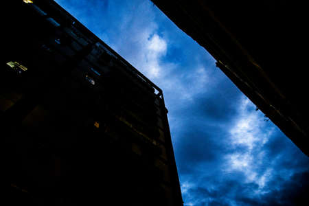 The view of the blue and clear sky and two buildings standing next to each otherの写真素材