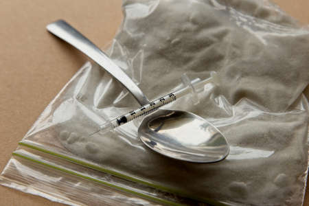 Drug abuse concept image consisting of a spoon, syringe, lighter and a bag of heroin.の写真素材