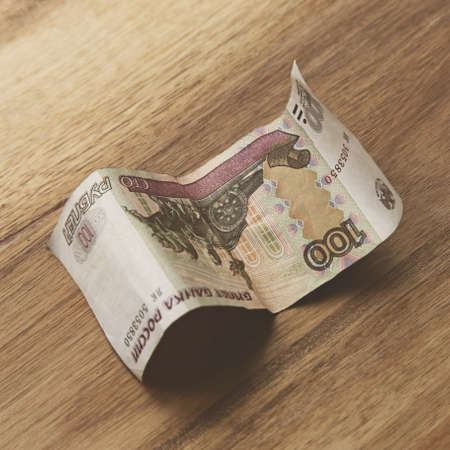 A high angle closeup shot of a banknote on a wooden surface