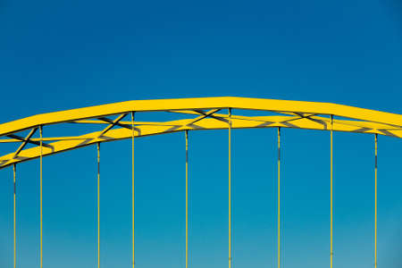 A closeup shot of the front part of a yellow arch under the blue skyの写真素材