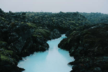 A high angle shot of a beautiful winding river flowing through the mossy rocksの写真素材