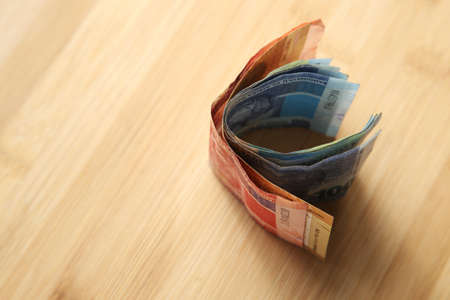 A high angle shot of a some cash money on a wooden surface