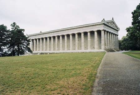 A wide shot of the Walhalla Hall of fame surrounded by trees and flat grass in Germanyのeditorial素材
