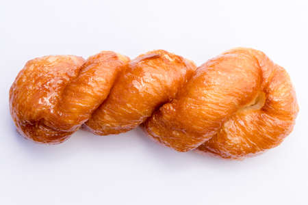 A closeup shot of a traditional South African koeksister donut on a white paperの写真素材