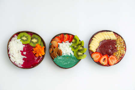 A high angle view of bowls with sliced fruits and sauces on the white tableの写真素材