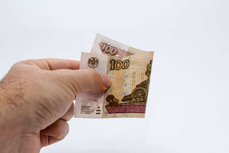 A high angle closeup shot of a person holding a banknote over a white backgroundの写真素材