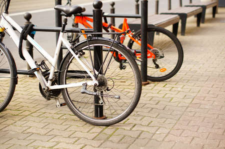 A low angle closeup shot of two bicycles parked on the sidewalkの写真素材