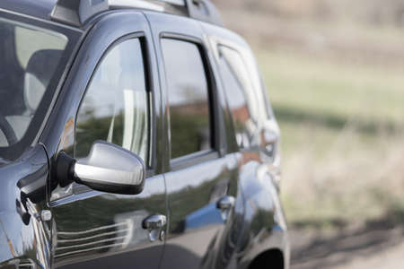 A closeup shot of a black car with a blurred background