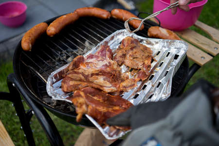 a high angle shot of barbeque and sausages on a grill