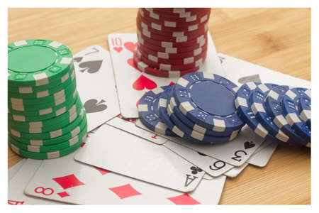 A high angle shot of a playing cards and poker chips on a wooden surface