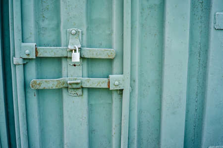 A locked metal door painted in baby blue colorの写真素材