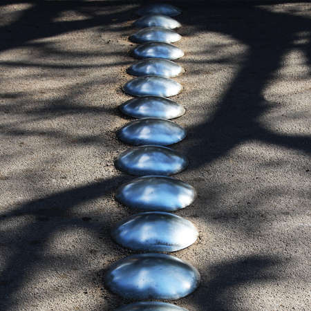 A high angle shot of metal bumps on the asphalt of the street during the day timeの写真素材