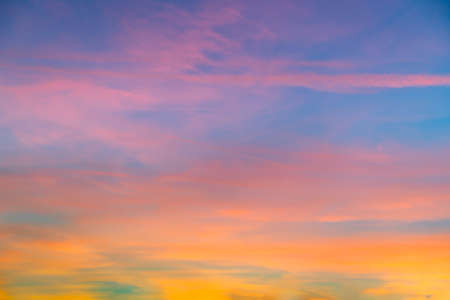 A beautiful shot of pink clouds in a clear blue sky with a scenery of sunriseの写真素材