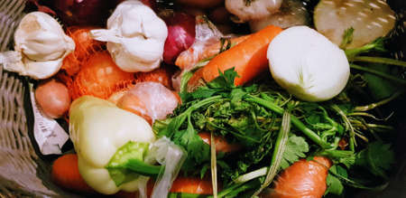 A lot of different fresh vegetables in a weaved basketの写真素材