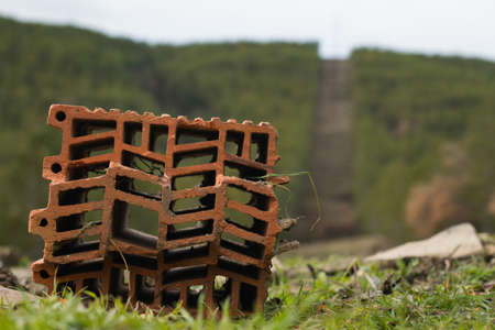 A selective focus shot of old brick with a neat pattern with electrical towers in the background in Sabinanigo, Spainの写真素材