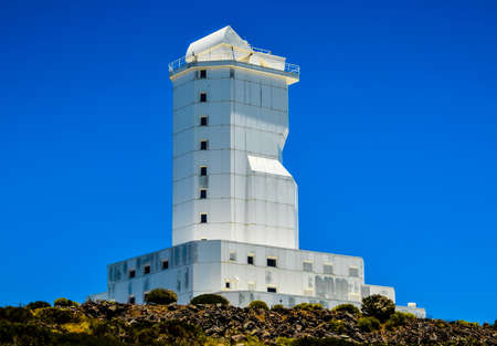 A landscape shot of a modern architectural white building of canary islands in spain with a clear blue sky in the backgroundの写真素材