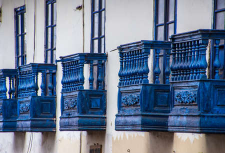A beautiful view of a white concrete building with blue stone balconies