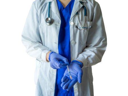 A young female caucasian doctor in a medical uniform and gloves preparing the syringe for an injection isolated on a white backgroundの写真素材