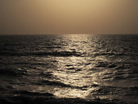 A beautiful shot of the sea reflecting the sun lights with a foggy backgroundの写真素材