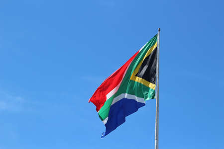 A low angle shot of the South African flag in the wind under the clear blue skyの写真素材