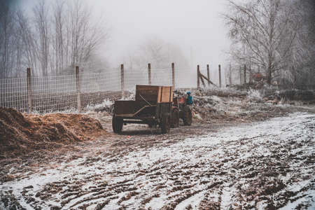 A snowy field with a wagon attached to a four-wheel motorcycleの写真素材