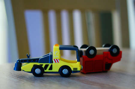 A closeup shot of two toy trucks on a wooden surface with a blurred background
