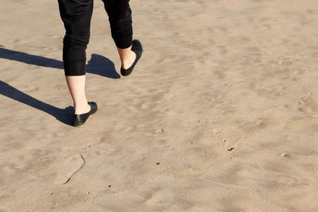 A person walking on a sandy surface leaving footprintsの写真素材