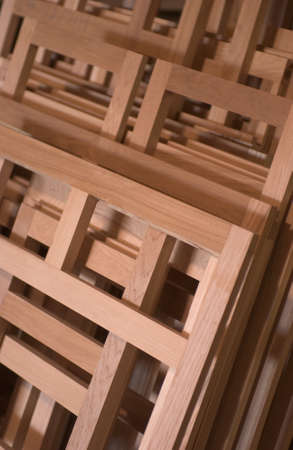 A vertical picture of lumber frames on top of each other under the lights