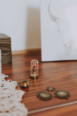 A small metal flower and other tiny objects put next to a larger painting