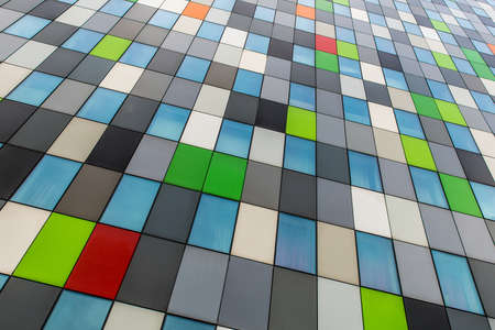 A low angle shot of a building with windows and different color walls