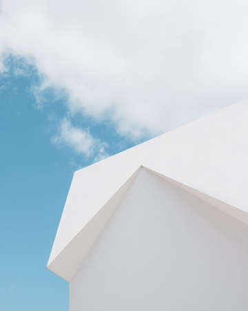 A low angle shot of a white building under a cloud and a blue skyの写真素材