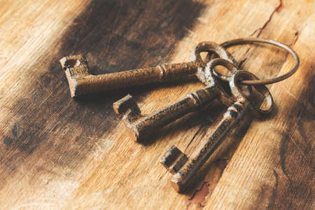 A closeup shot of old vintage keys on a wooden surfaceの写真素材