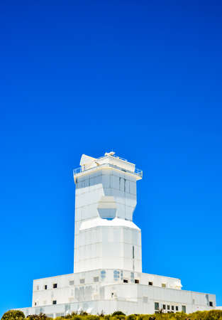 A low angle shot of a modern architectural white building of canary islands in spain with a clear blue sky in the backgroundの写真素材