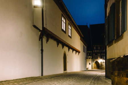A beautiful night view of an alleyway with white buildings under artificial lightsの写真素材