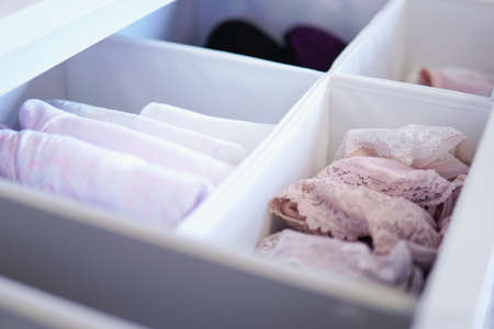 A lot of different folded clothes perfectly arranged in a closet - Marie Kondo Konmari method conceptの写真素材