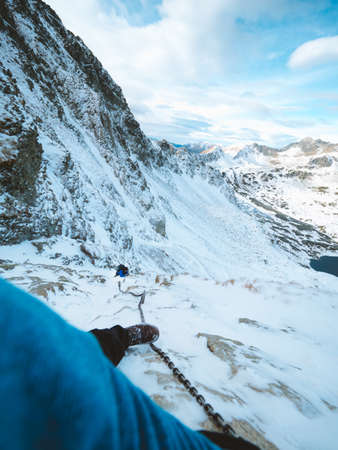 A vertical shot of a mountaineer climbing the Tatra Mountains covered with snow in Polandの写真素材