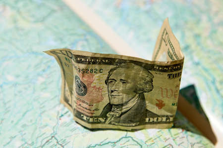 A high angle shot of a US 10 dollar cash on a geographic mapの写真素材