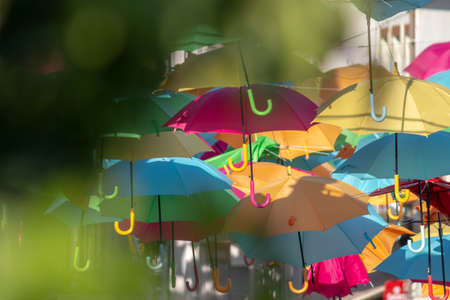 A framed shot of a beautiful display of colorful hanging umbrellasの写真素材