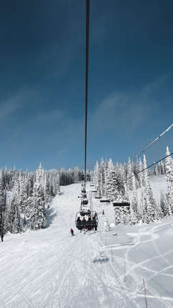 A ski chairlift with a wonderful view of the slopes on a bright winter day.のeditorial素材