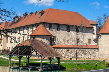 OTOCEC, SLOVENIA - Sep 15, 2019: Old castle Otocec, with wooden bridge crossing the charming river Krka.のeditorial素材