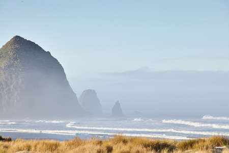 A scenery of the Haystack Rock in the morning fog at Cannon Beach, Oregonの写真素材