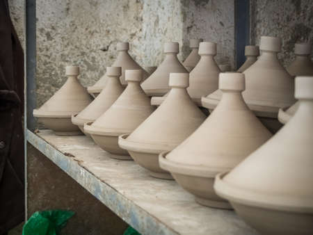 A lot of handmade ceramic pottery on the shelf in a marketの写真素材