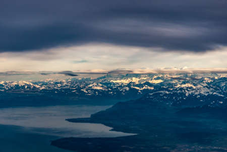 Moody view of the lake and Alps with a band of grey cloud